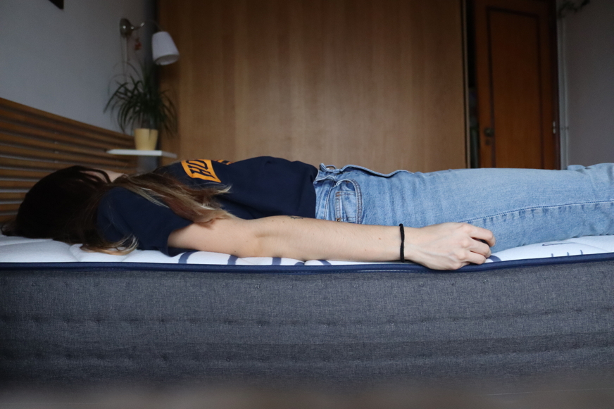 Pessoa a dormir de costas num colchão